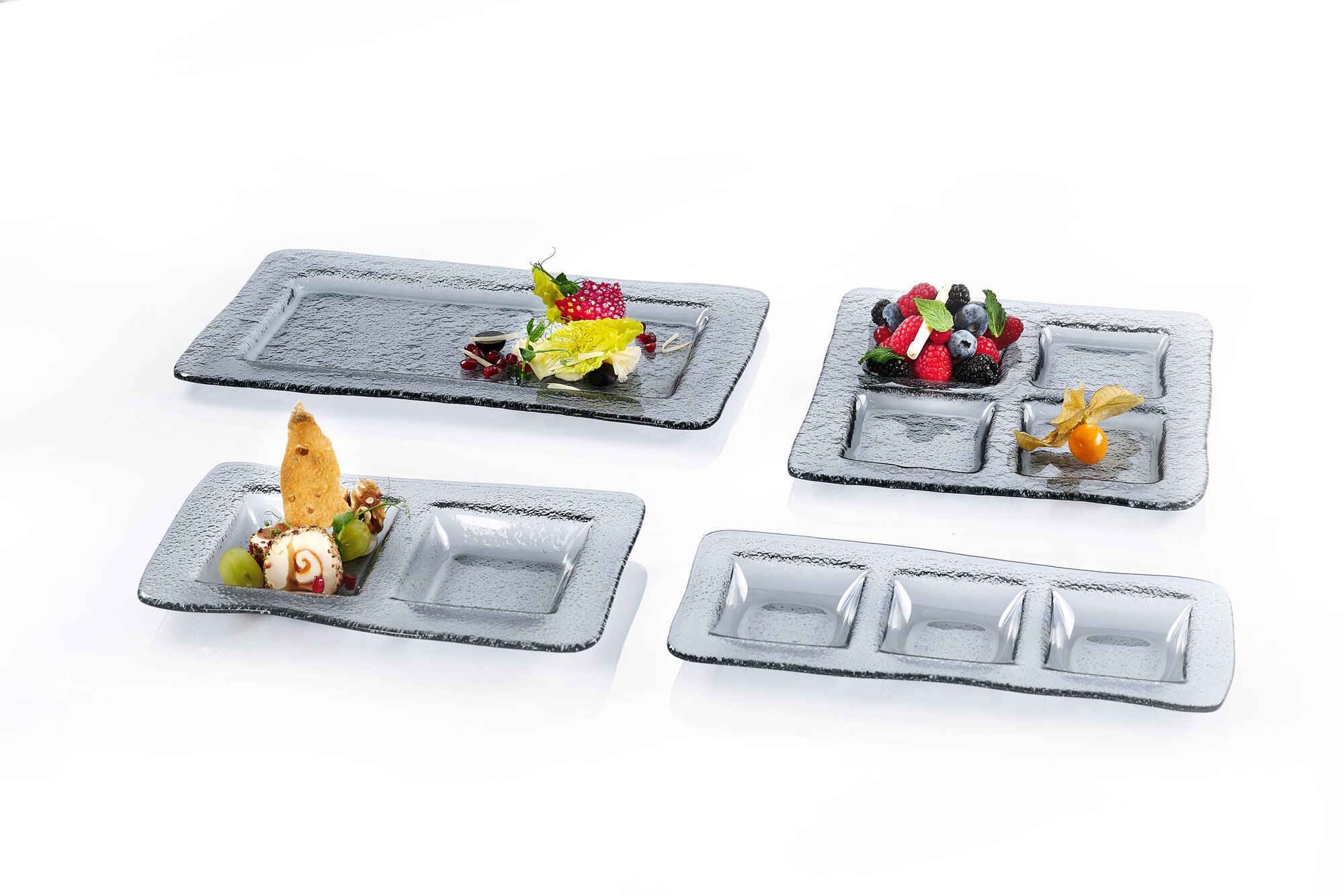 Verschiedene Glasplatten mit Fächern und kleinen Speisen dek