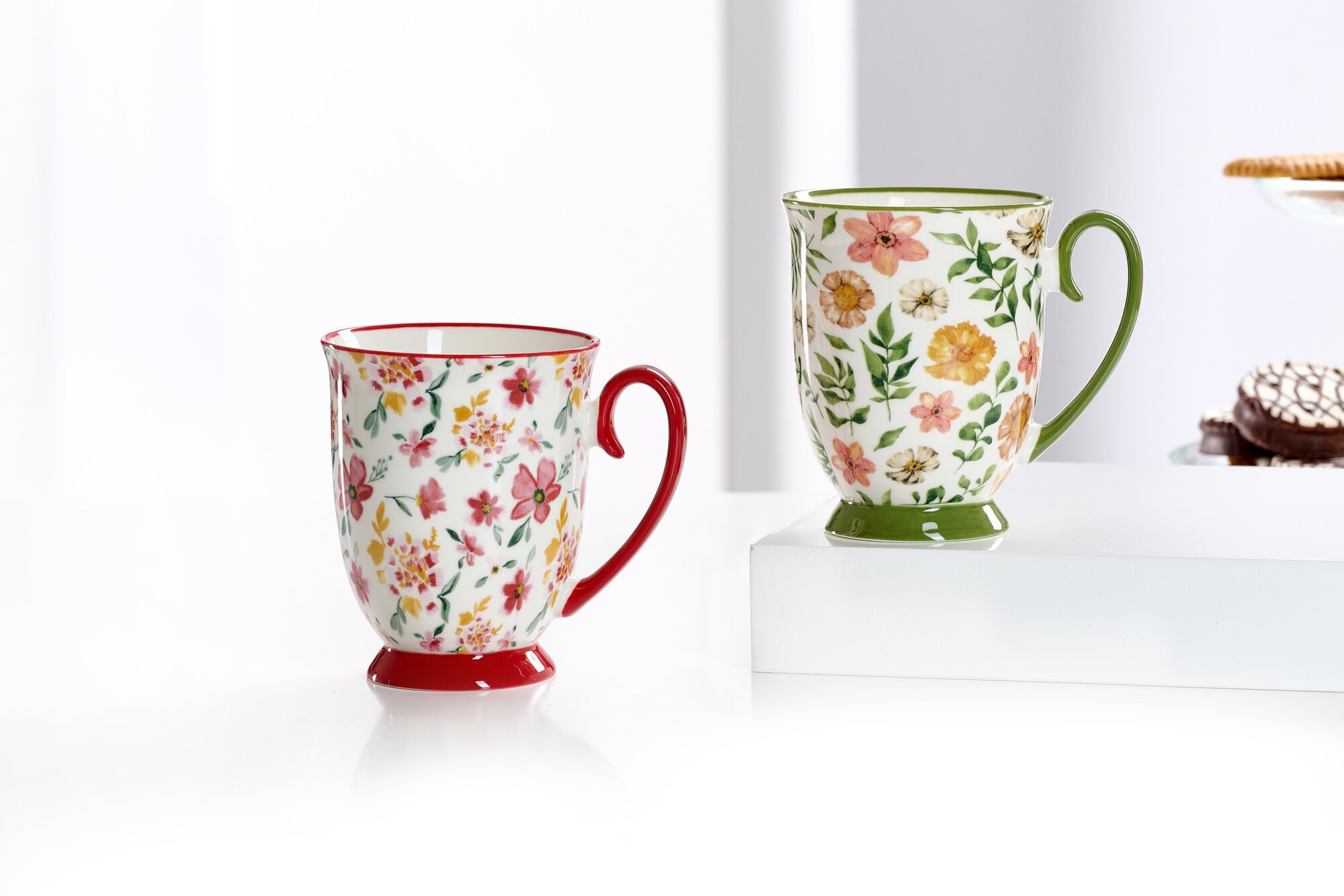 Zwei Keramiktassen mit Blumenmuster auf weißem Untergrund