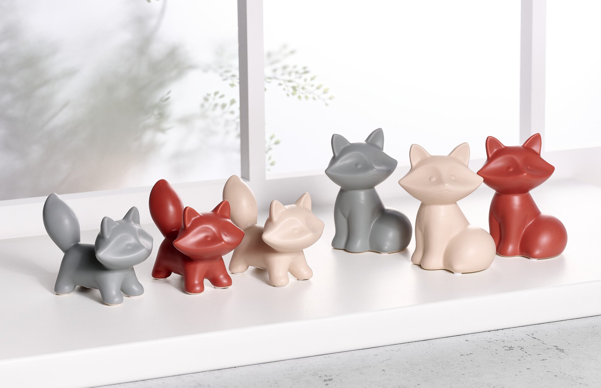 Sechs Deko-Figuren in Form von Füchsen in Grau, Rot und Beig