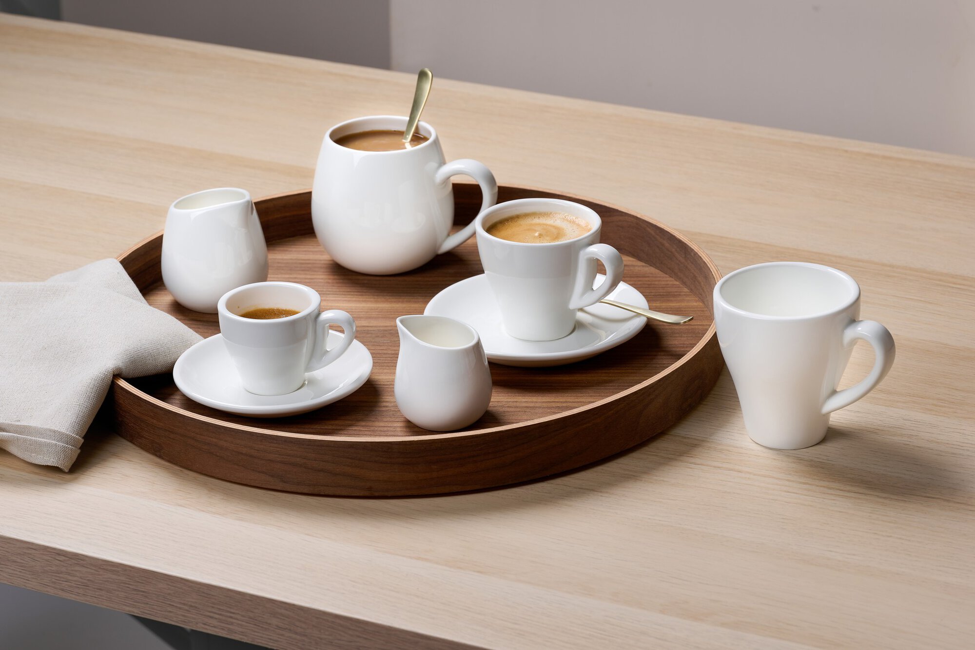 Kaffeeservice aus weißem Porzellan mit Tassen und Milchkännc