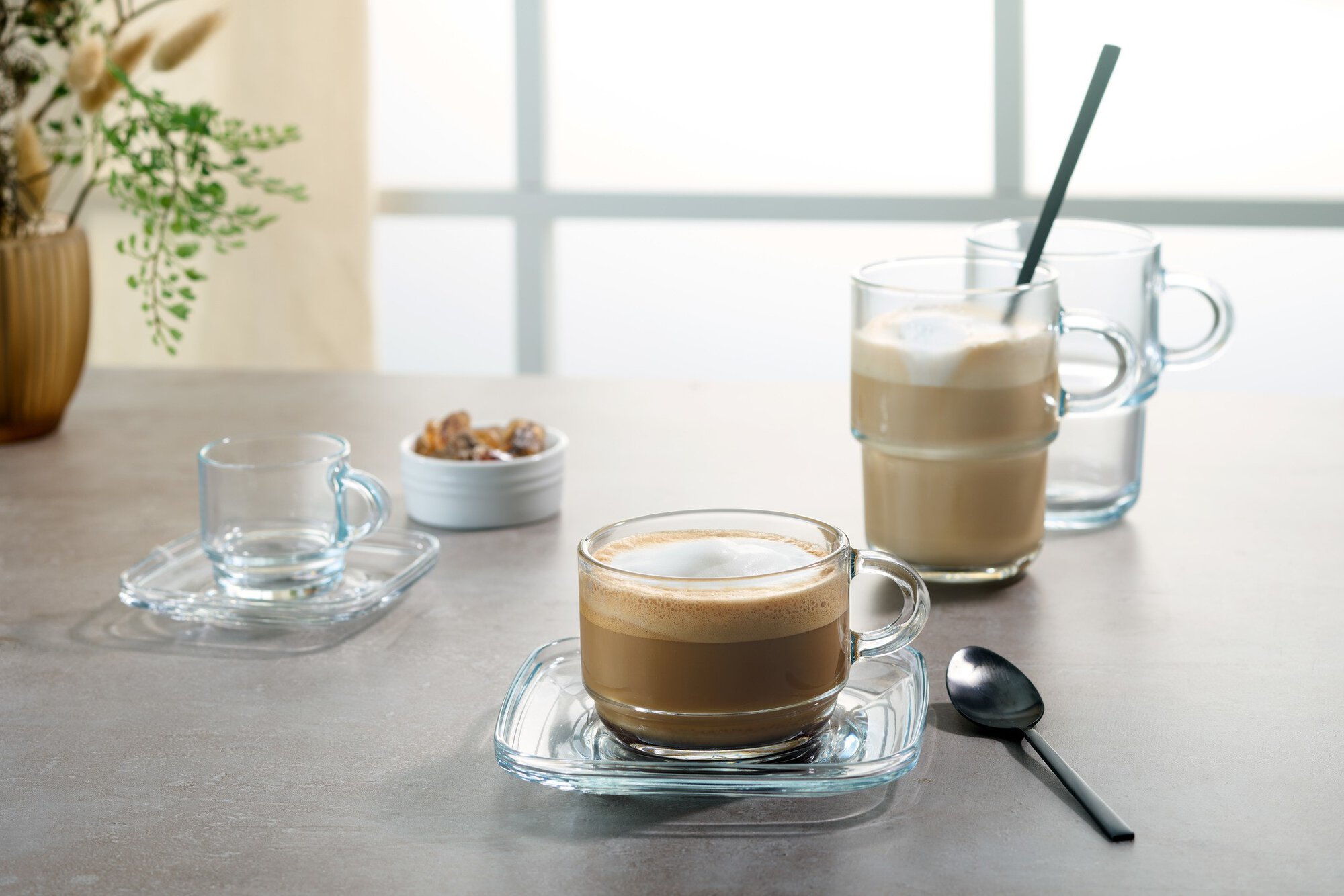 Latte Macchiato im Glas mit Löffel auf Tisch