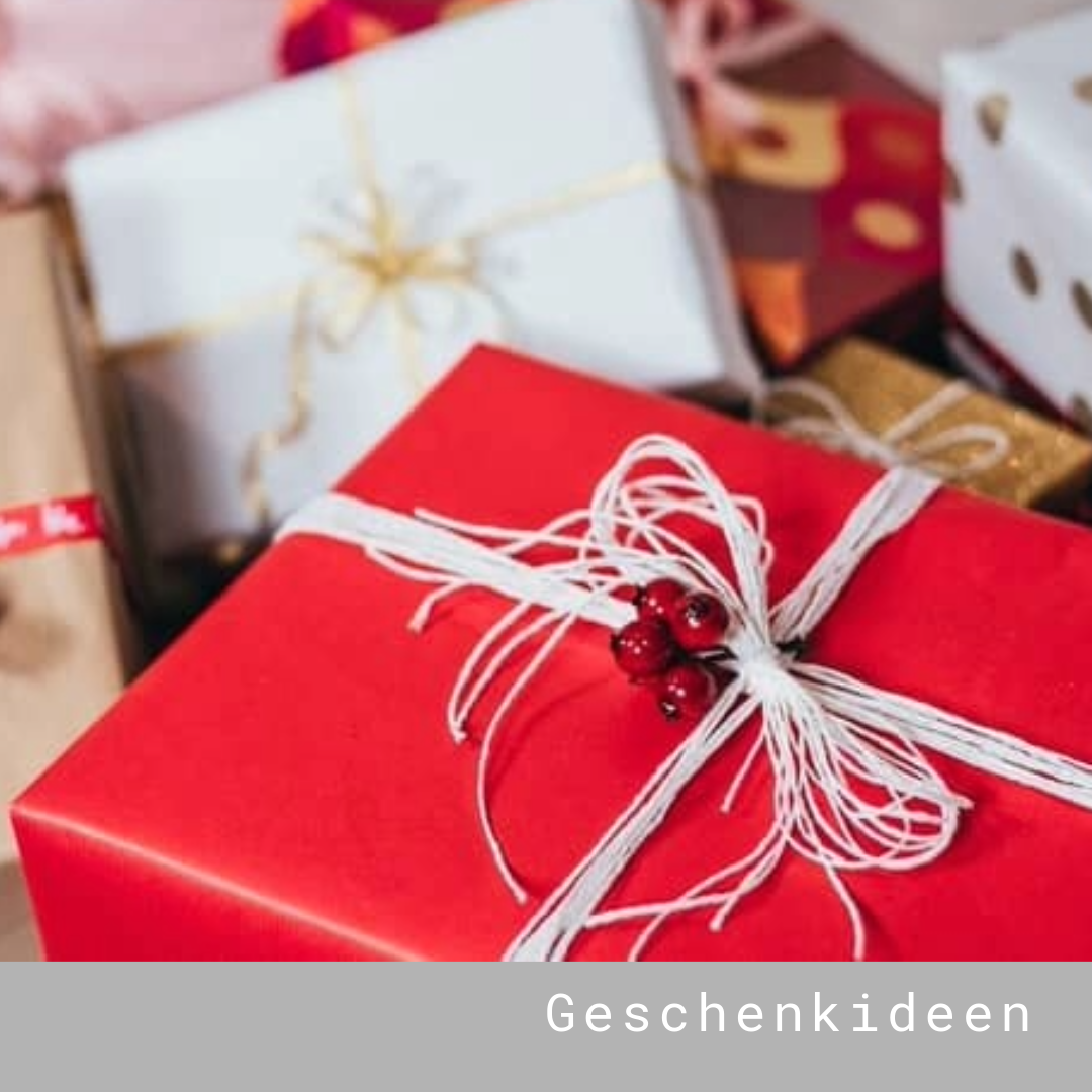 Rotes Geschenk mit weißer Schnur und roten Beeren
