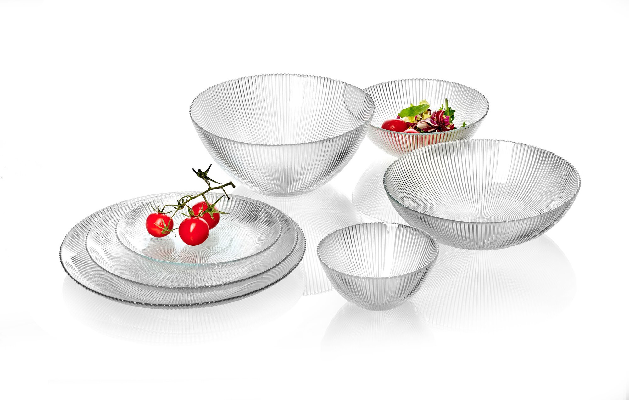 Gläsernes Geschirrset mit Tomaten und Salat