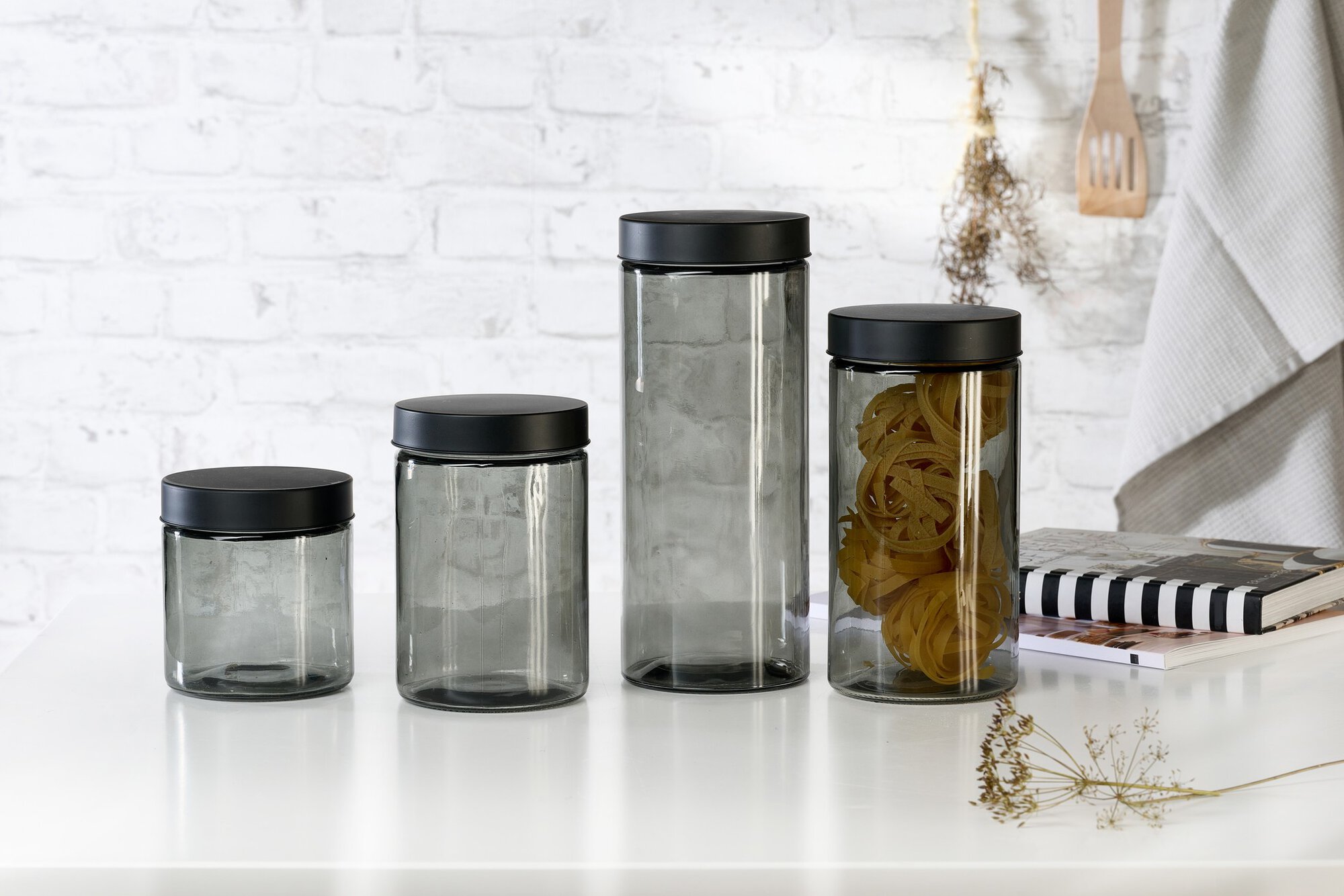 Set aus vier Glas-Vorratsbehältern mit schwarzen Deckeln auf