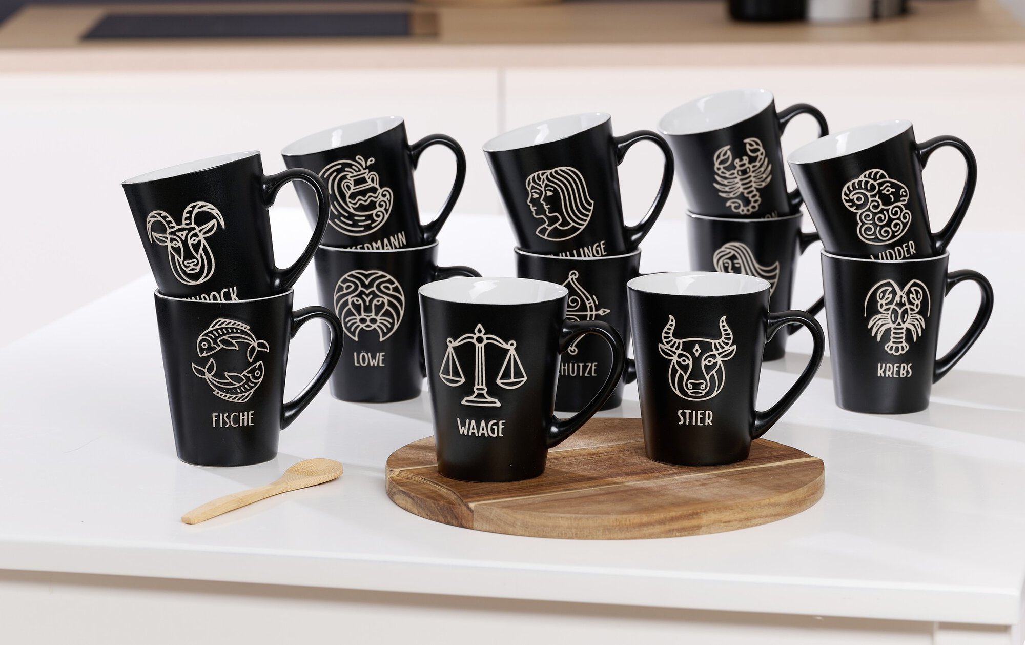 Set aus schwarzen Tassen mit verschiedenen Sternzeichen auf