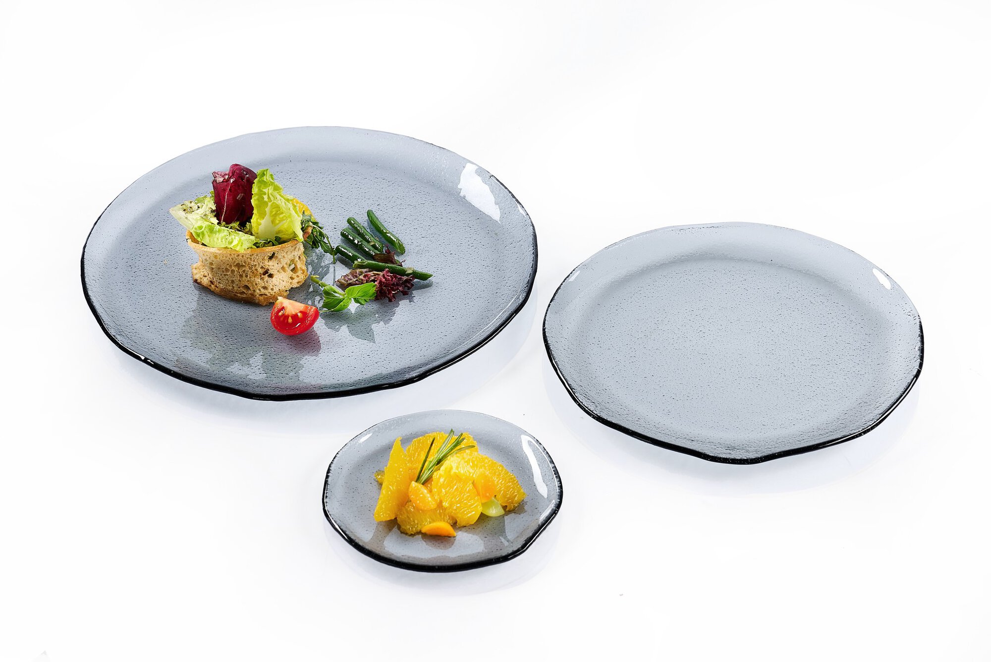 Set mit drei braunen Glastellern, zwei belegt, einer leer